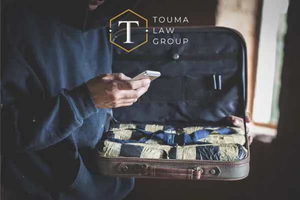 un hombre hablando por teléfono junto a una bolsa llena de paquetes de drogas
